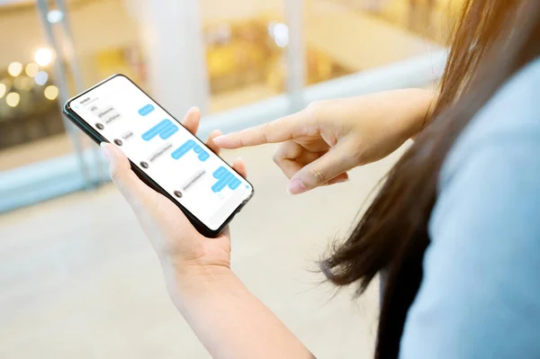 Cep telefonu kullanan bir kadın. Cep telefonundan arkadaşıyla sohbet ediyor.