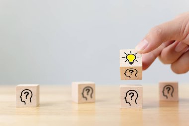 Yaratıcı fikir ve yenilik kavramı. İnsan sembolü ve ampul simgesiyle ahşap küp bloğunu ters çevir