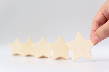Beyaz arka plana beş yıldızlı ahşap bir el. En iyi iş hizmetleri derecelendirme müşteri deneyimi konsepti