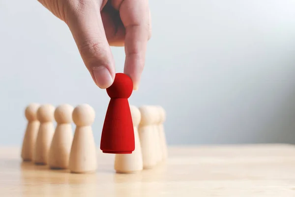 Human resource, Talent management, Recruitment employee, Successful business team leader concept. Hand chooses a wooden people standing out from the crowd.