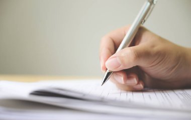 Başvuru formu doldurma belgesini imzalayan adamın eli
