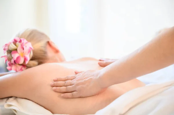 Health care and thai massage. Beautiful woman getting back and shoulder massage in spa salon