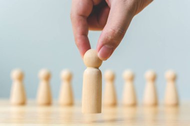 İnsan kaynakları, yetenek yönetimi, işe alım çalışanı başarılı iş dünyası lideri konsepti. El, kalabalığın arasından çıkan tahta insanları seçer..