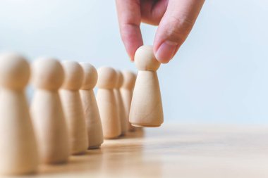 İnsan kaynakları, yetenek yönetimi, işe alım çalışanı başarılı iş dünyası lideri konsepti. El, kalabalığın arasından çıkan tahta insanları seçer..