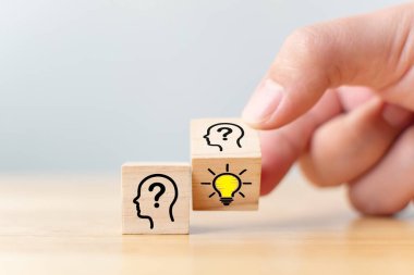 Yaratıcı fikir ve yenilik kavramı. İnsan sembolü ve ampul simgesiyle ahşap küp bloğunu ters çevir