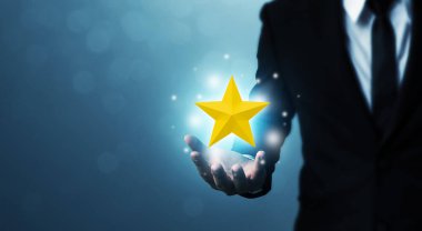 İş adamının elleri beş yıldızlı altın bir şekle sahiptir. En iyi iş hizmetleri derecelendirme müşteri deneyimi konsepti