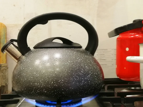 Tea Kettle with Steam Over A Hot Gas Stove