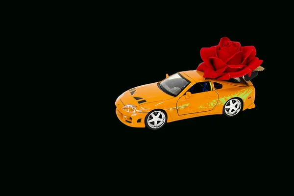 toy car with roses on black background