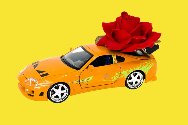 toy car with roses on yellow background