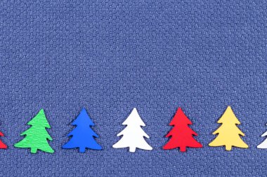 Noel kartı ile mavi kumaş bir arka plan üzerinde renkli Noel ağaçları