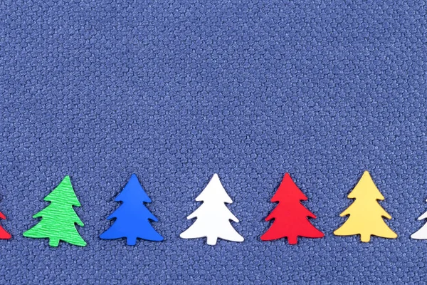 Kartki świąteczne z kolorowe choinki na tle niebieski tkaniny — Zdjęcie stockowe