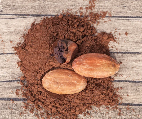 Kakaové boby a prášek na dřevěné prkno — Stock fotografie