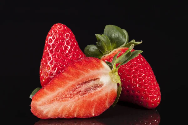 Cut and whole fresh fruits of red strawberry isolated on black background — Stock Photo, Image