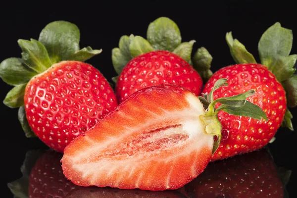 Cut and whole fresh fruits of red strawberry isolated on black background — Stock Photo, Image