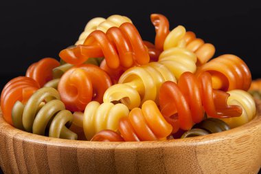 Sarmal makarna trottole tricolore siyah arka plan üzerine izole ahşap kase