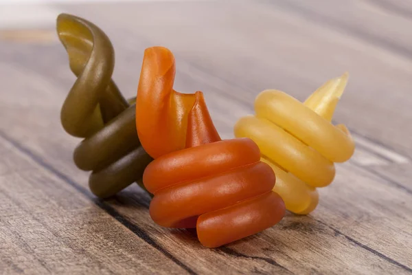 Pasta a spirale trottole tricolore su tavola di legno — Foto Stock