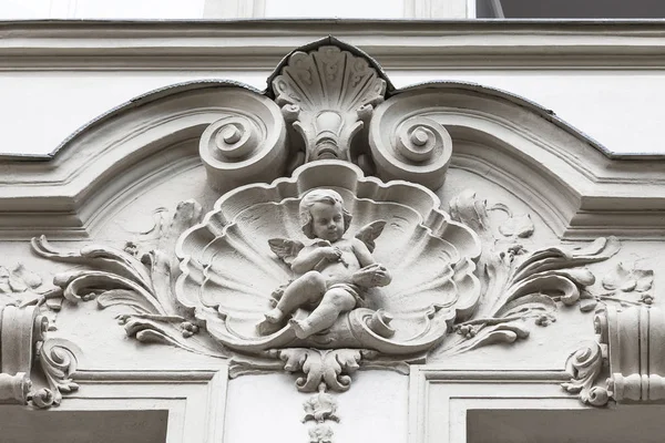 Relief on facade of old building, cupid, Prague, Czech Republic
