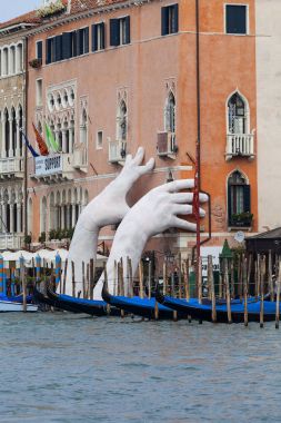 Lorenzo Quinn Grand Canal Sudan, Venedik, İtalya, çıkıntılı iki dev el koyarak heykelini destek