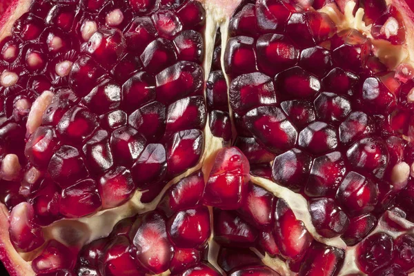 Fruit of red pomegranate, half with seeds, background, close up — Stock Photo, Image