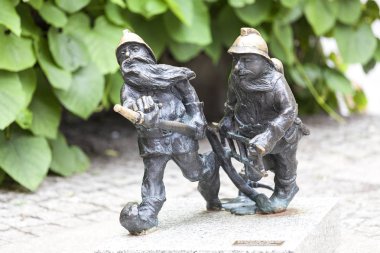 Wroclaw cüce, küçük peri masalı bronz heykelcik yan yürüyüşte, itfaiyeciler, Wroclaw, Polonya