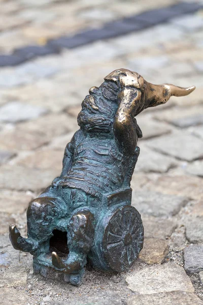 Wroclaw dwarf, small fairy-tale bronze figurine on the side walk, invalid wheelchair, Wroclaw, Poland — Stock Photo, Image