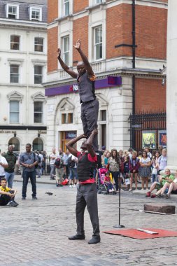 Covent Garden Market, popüler alışveriş ve turistik siteye göstermek siyah circus oyuncular sokakta, London, Büyük Britanya