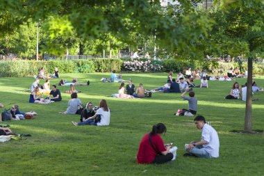Şehir merkezinde, London, Londra, İngiltere gevşeme geleneksel bir şekilde Park'ın bahçesinde oturan insanlar