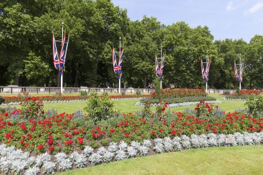 London, Büyük Britanya, 21 Haziran 2017: Meydanı önünde Buckingham Sarayı flowerbed ve bayraklar, London, Büyük Britanya.