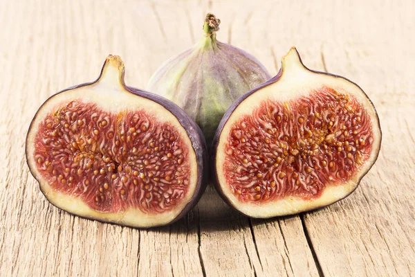 Fresh figs, half and whole on wooden plank, close up. Food photo — Stock Photo, Image