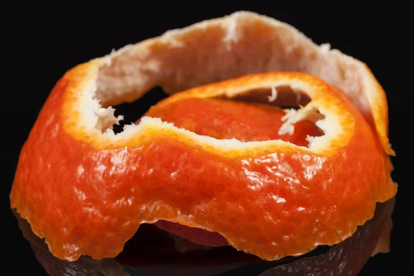 Peeled mandarine skin isolated on black background, close up. — Stock Photo, Image