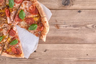 Güzel taze pizza jambon ve ahşap arka plan üzerinde domates