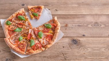 Güzel taze pizza jambon ve ahşap arka plan üzerinde domates