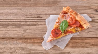 Güzel taze pizza jambon ve ahşap arka plan üzerinde domates