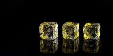 siyah arka plan üzerine üç sarı buz küpleri