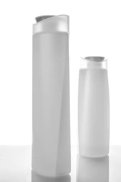 Dois frascos de champô no fundo branco. preto e branco — Fotografia de Stock