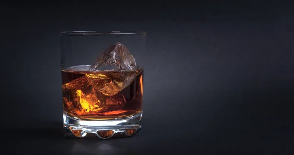 Whisky con cubetti di ghiaccio su sfondo scuro Foto Stock