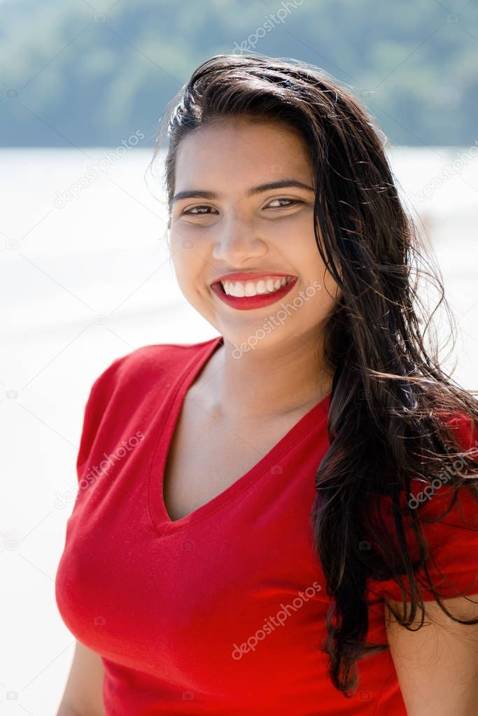Happy young woman girl with a big smile by the beach enjoying the sunshine