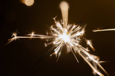 Yanan kıvılcım çubuğu yıldız ışığı havai fişek havai fişeği kara ılık arka plan elde tutulur