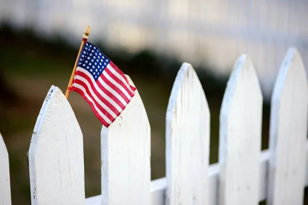 Bandeira americana em cerca de piquete branco — Fotografia de Stock
