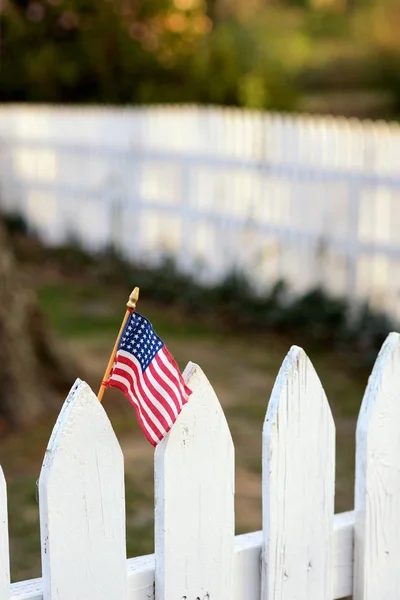 백색 말뚝 울타리에 미국 국기 스톡 사진