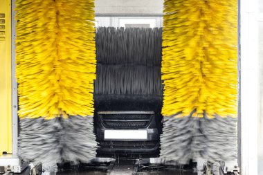 Otomatik bir tünel araba yıkama makinesinde otomatik fırçalarla yıkanıyor.