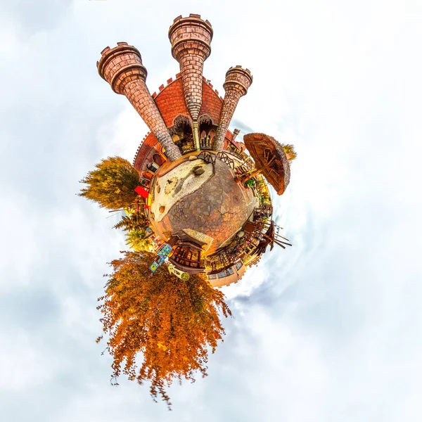 Tiny planet with fantasy old children\'s castle and trees. Orange color. Autemn.