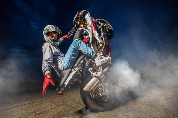 Moto piloto fazendo uma acrobacia em sua moto — Fotografia de Stock