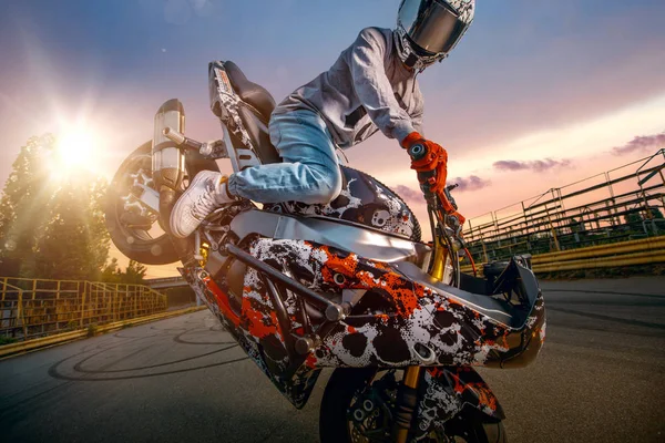 Moto piloto fazendo uma acrobacia em sua moto — Fotografia de Stock