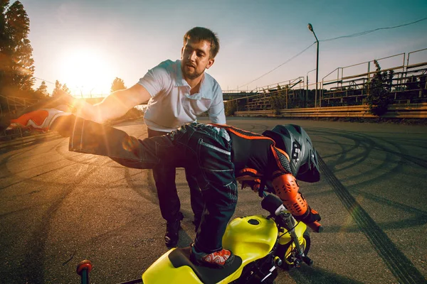 Trainer leert kleine fietsers te doen stunts op een motorfiets — Stockfoto