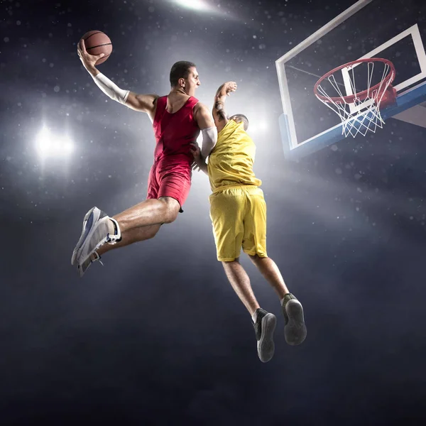 Basketball players on big professional arena makes slam dunk