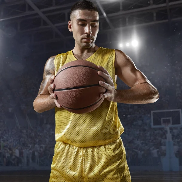 Баскетболист держит мяч на профессиональной арене — стоковое фото