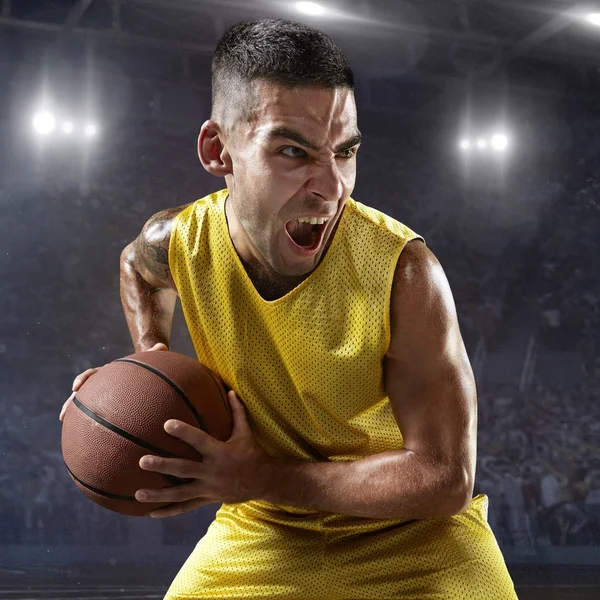 Kosárlabda játékos tartsa a labdát a szakmai arena — Stock Fotó