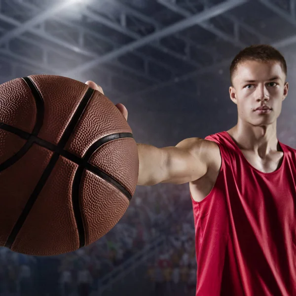 Kosárlabda játékos tartsa a labdát a szakmai arena — Stock Fotó