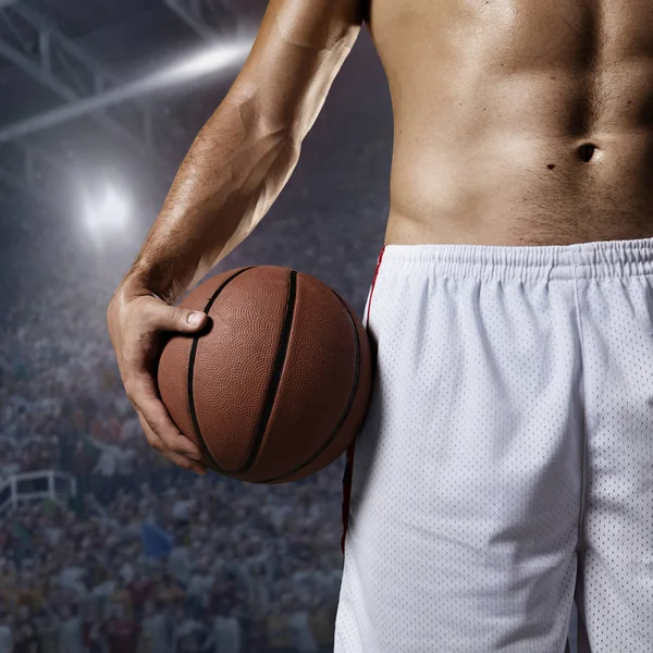 Баскетболист держит мяч на профессиональной арене — стоковое фото